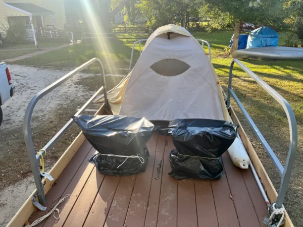 A boat with two bags on it and some trees in the background