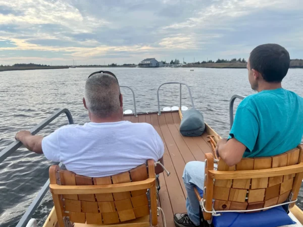 Two men sitting on a boat in the water.