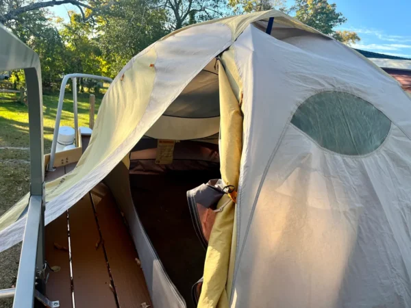 A tent is open on the deck of a boat.