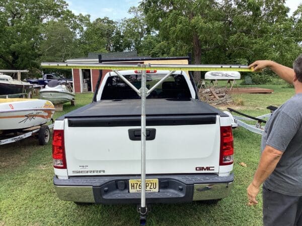 A white truck with a rack on the back of it.