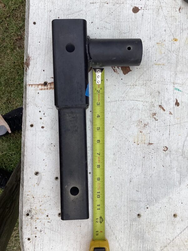 A black handle and a yellow ruler on top of a table.