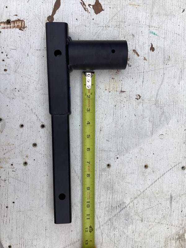 A black handle and yellow ruler on the ground.